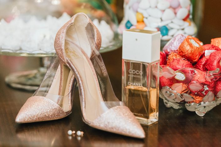Παπούτσια νύφης, σκουλαρίκια, άρωμα, σοκολατάκια, κουφέτα στην προετοιμασία για τον γάμο
